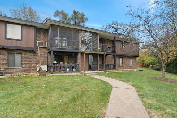 Front view of a two-story brick apartment building with balconies.