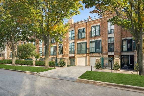 Front view of a multi-story brick building with large windows and garages.