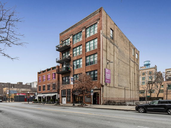 Front view of a multi-story brick building with balconies.