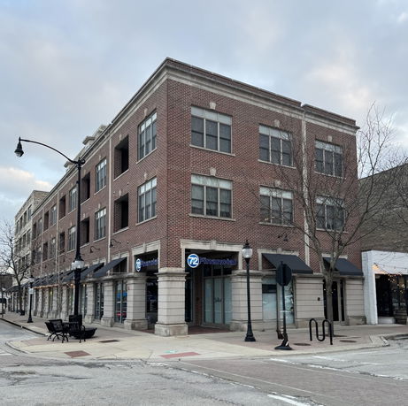 Front view of a multi-story commercial brick building on a corner street.