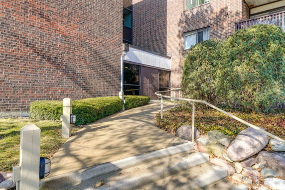 Front view of a building with brick exterior and entrance path.