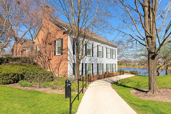 Front view of a two-story house with a brick facade and white siding.