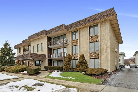Front view of a multi-story brick building with balconies.