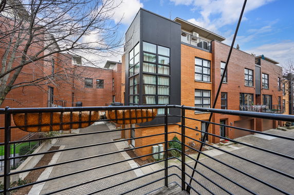 Front view of a modern brick building with large glass windows and balconies.