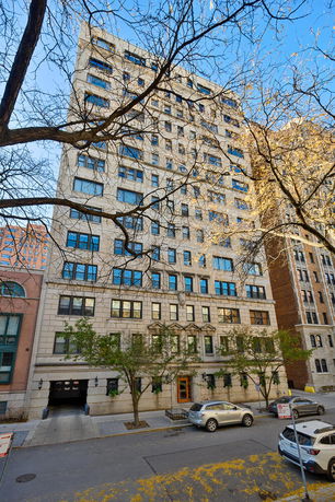 Front view of a multi-story apartment building with a neutral facade and multiple windows.