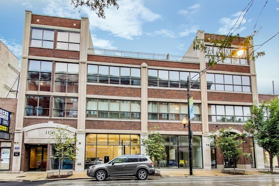 Front view of a modern three-story commercial building with large windows.
