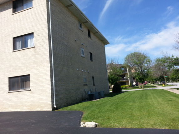 Side view of a multi-story brick building with multiple windows.