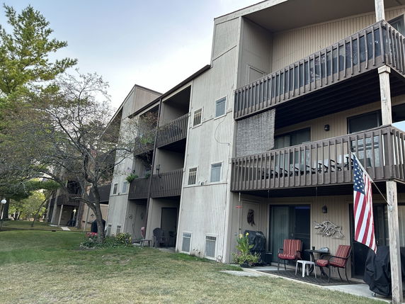 Front view of a multi-story building with balconies and an American flag displayed.