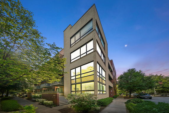 Front view of a modern multi-story building with large windows.