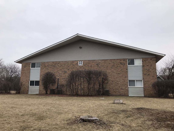 Front view of a two-story building with brick exterior and a sloped roof.
