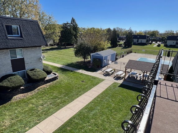 Panoramic view of residential area with lawns, pathways, and a swimming pool.