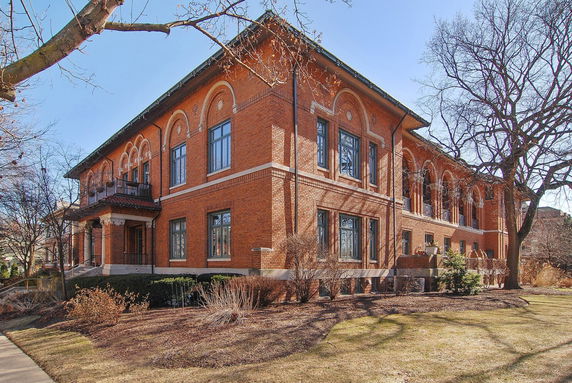 Front view of a large two-story brick building with arched windows.