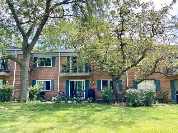 Front view of a two-story brick apartment building with balconies.