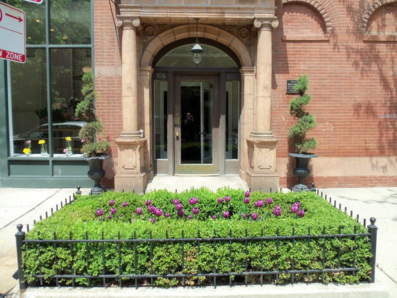 Front view of a building entrance with an arched doorway and decorative columns.