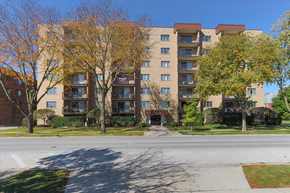 Front view of a multi-story apartment building with balconies.
