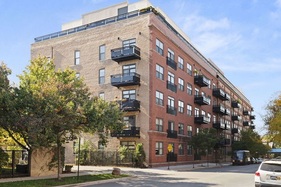 Front view of a multi-story apartment building with balconies.