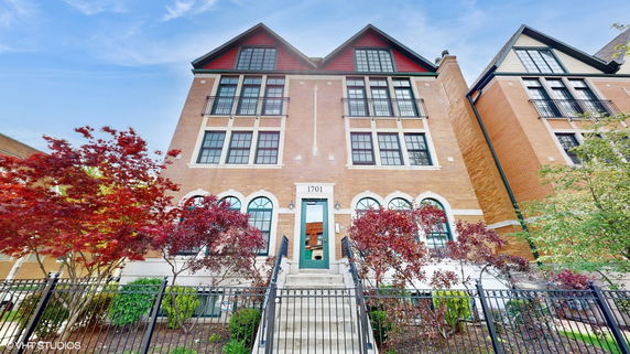 Front view of a multi-story brick building with large windows and a central entrance.