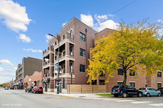 Front view of a multi-story brick building with balconies.