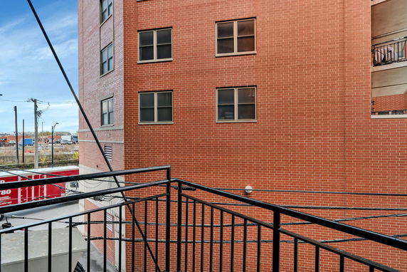 View from a balcony showing a red brick building and surrounding urban area.