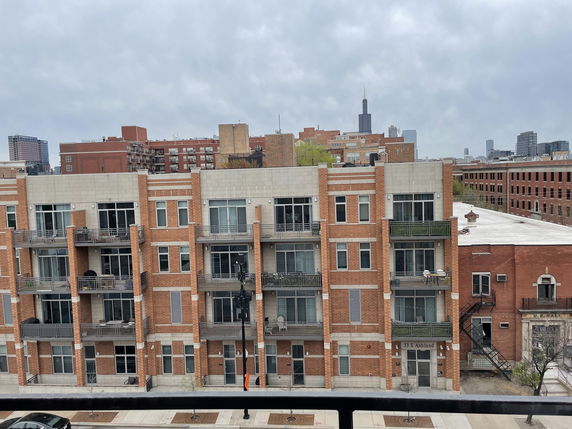 Front view of a multi-story brick building with balconies.