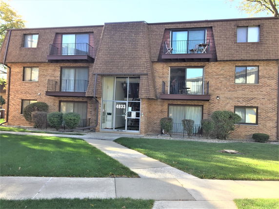 Front view of a three-story apartment building with balconies.