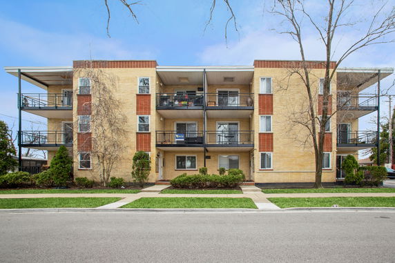 Front view of a multi-story apartment building with balconies.