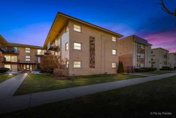 Front view of a multi-story apartment building at dusk.