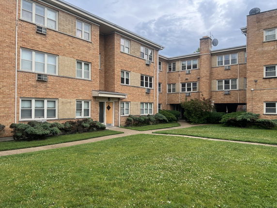 Front view of a multi-story brick apartment building.