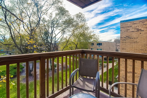 View from a balcony overlooking trees and surrounding buildings
