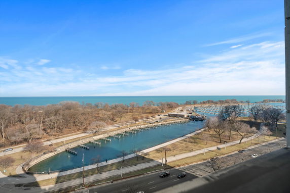 Panoramic view of a waterfront area with trees and walking paths by the water.