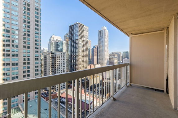 Balcony view overlooking a cityscape with numerous high-rise buildings.