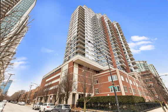 Front view of a multi-story residential building with large glass windows and balconies.
