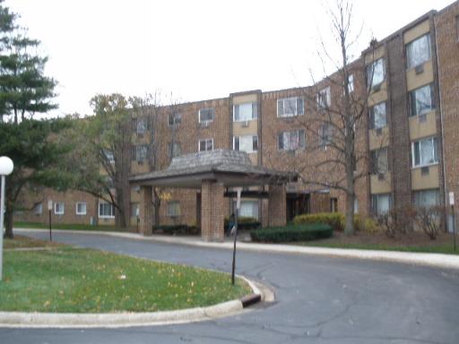 Front view of a multi-story residential building with a covered entrance.