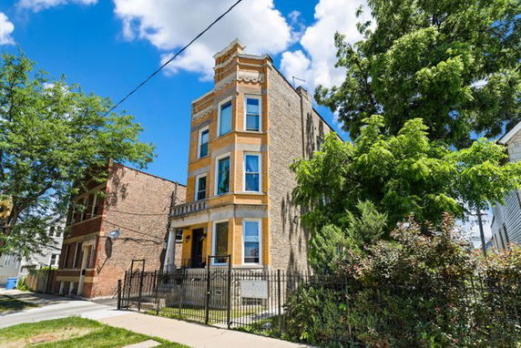 Front view of a three-story brick building with decorative elements.