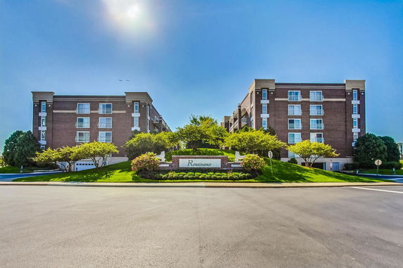 Front view of two symmetrical four-story apartment buildings with brick facades.