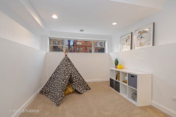 Indoor play area with a small tent and shelves.