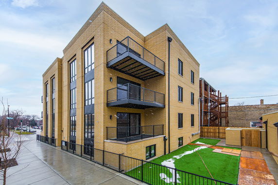 Front view of a multi-story apartment building with balconies.