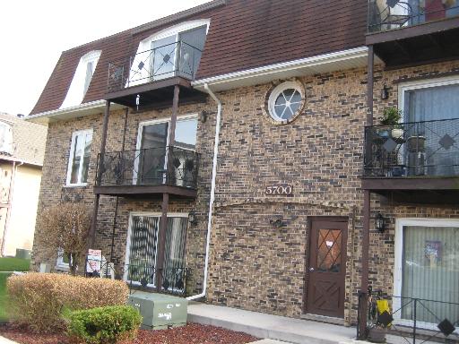 Front view of a multi-story brick building with balconies.