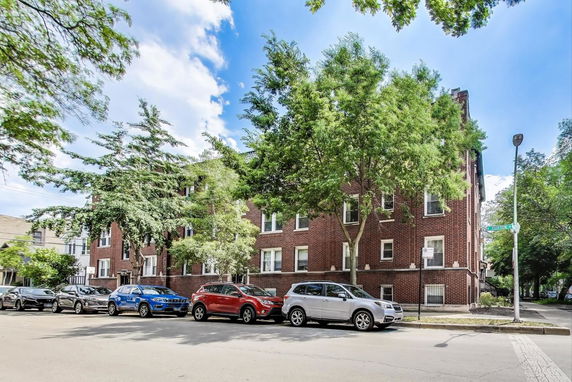 Front view of a multi-story brick building with several windows.
