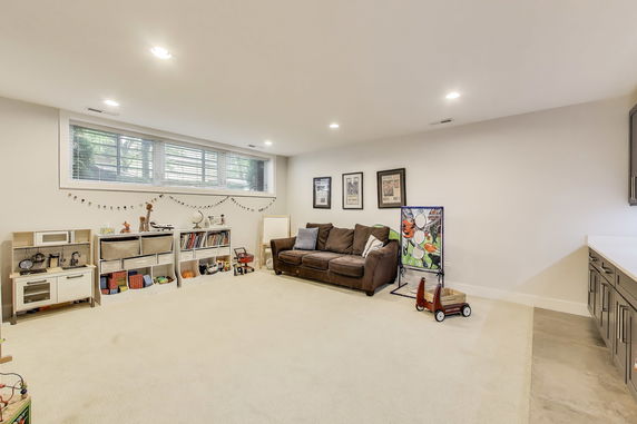 Room with toys, a couch, and a play kitchen area