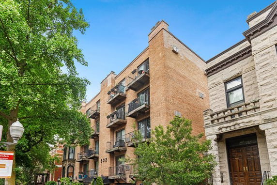 Front view of a multi-story brick building with balconies.