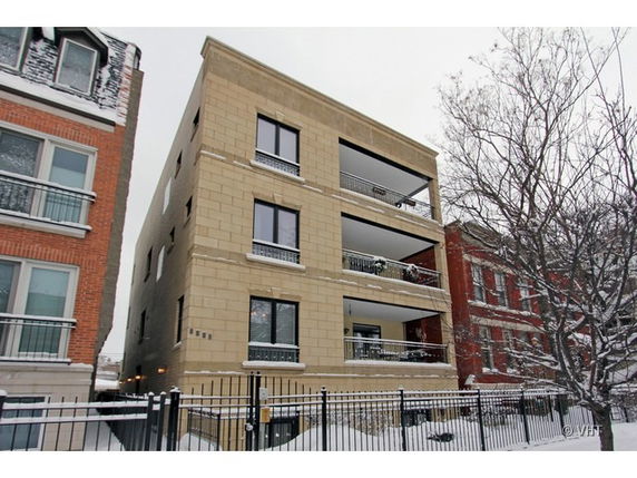 Front view of a multi-story residential building with balconies.