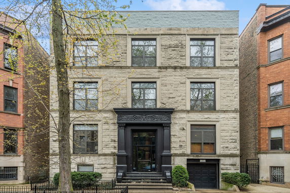 Front view of a multi-story building with a detailed entrance and stone facade.