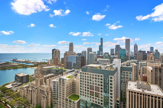 Panoramic view of a city skyline with tall buildings and a waterfront.