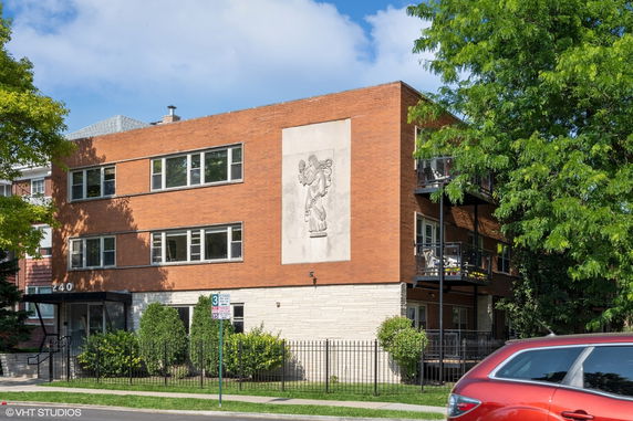 Front view of a two-story red brick building with a decorative relief on the facade.
