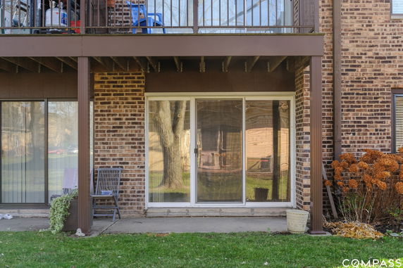 Front view of a brick building with sliding glass doors and balcony.