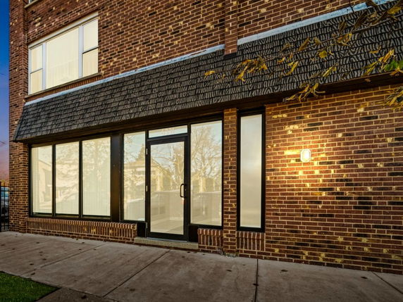 Front view of a building with brick exterior and large glass windows.
