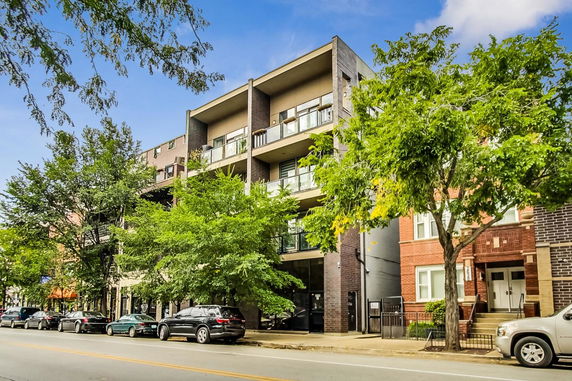 Front view of a multi-story residential building with balconies.