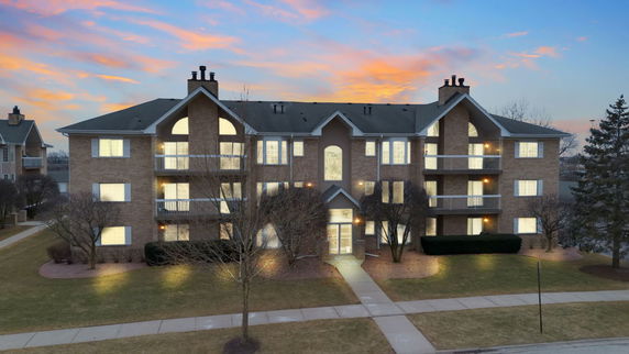 Front view of a multi-story apartment building with balconies.