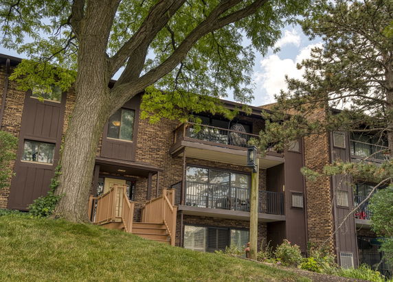 Front view of a multi-story apartment building with balconies and a central entrance.